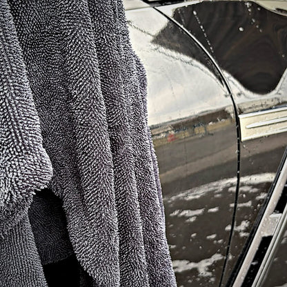 Serviette de séchage MIRE 60 × 90 cm suspendue sur le flanc mouillé d'une Nissan GT-R noire