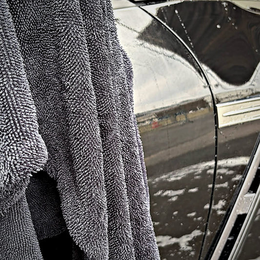 Serviette de séchage MIRE 60 × 90 cm suspendue sur le flanc mouillé d'une Nissan GT-R noire