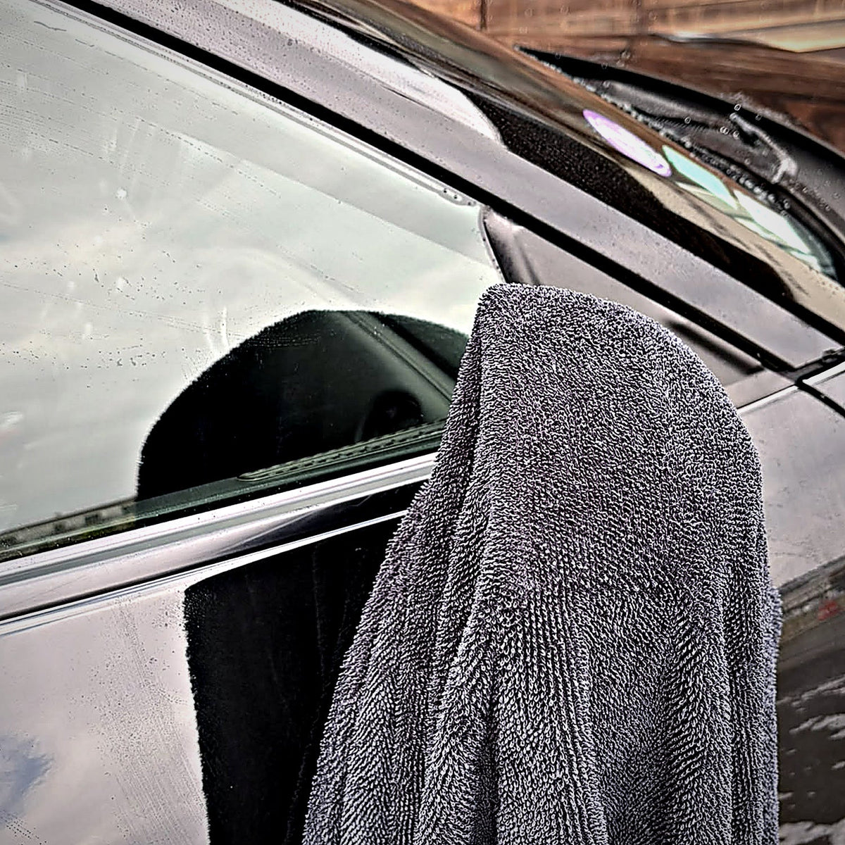 Serviette MIRE 60 × 90 cm posée sur la portière d'une Nissan GT-R noire