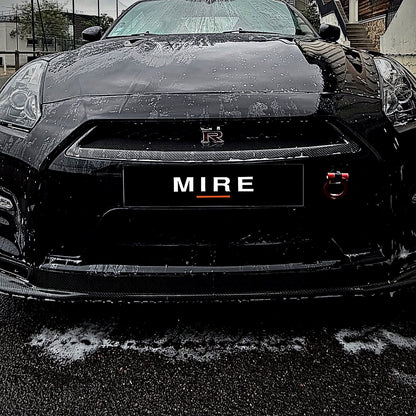 Face avant d'une Nissan GT-R noire portant une plaque MIRE